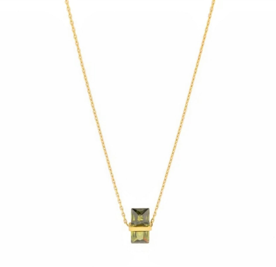 Gold necklace with a green gemstone pendant on a white background
