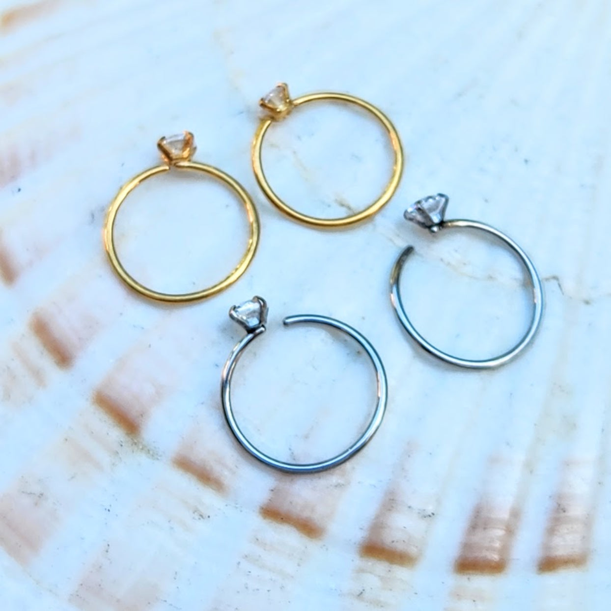 Set of gold and silver hoop earrings on a marble surface