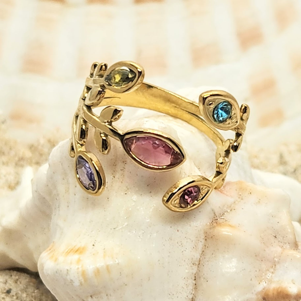 Gold ring with multicolored gemstones on a shell