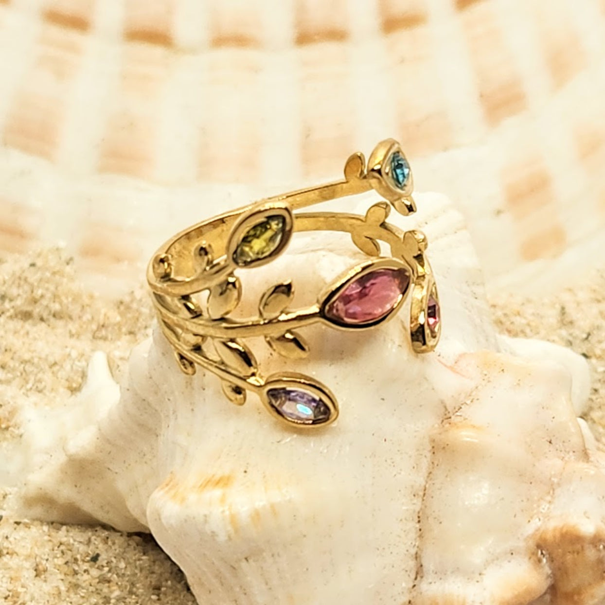 Gold ring with colorful gemstones on a shell
