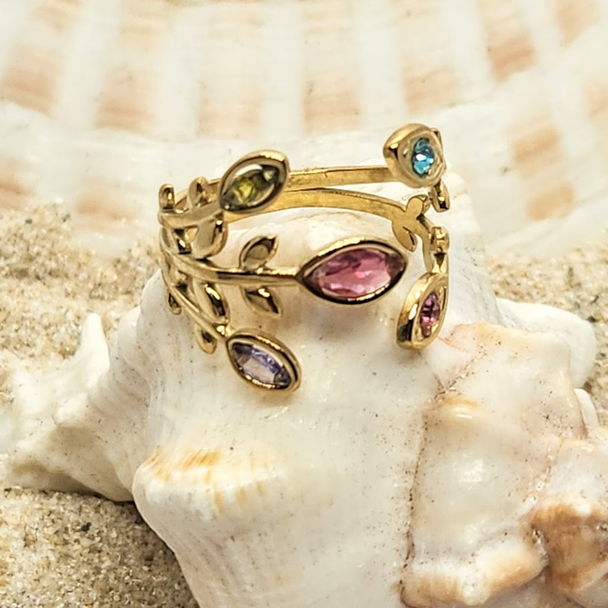 Gold ring with colorful gemstones on a shell