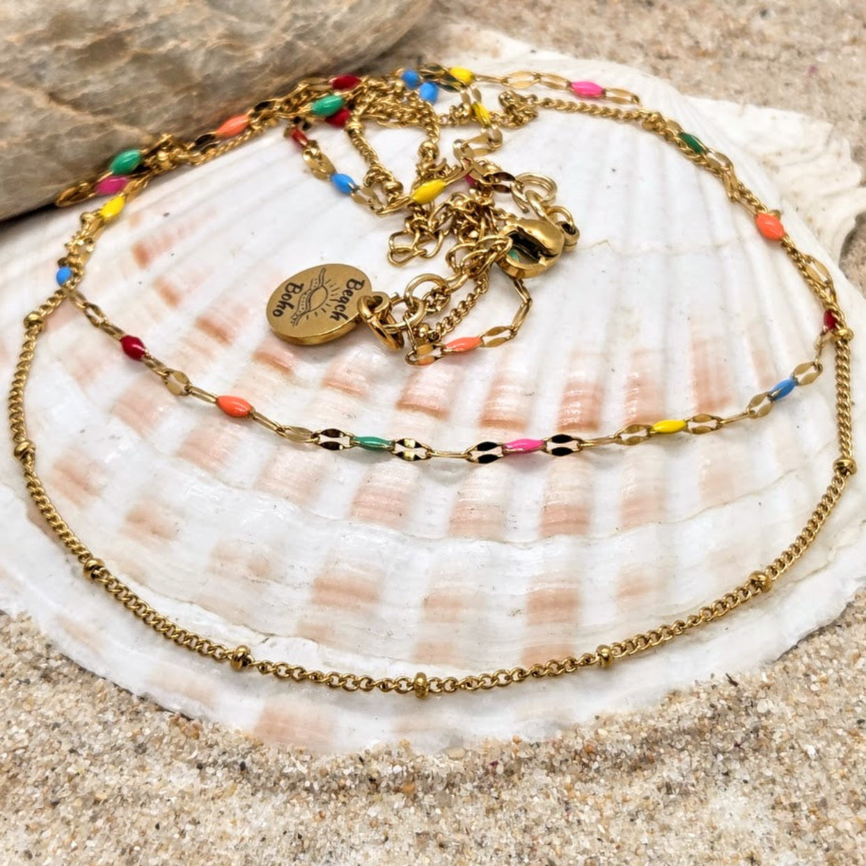 Gold necklace with colorful beads on a seashell