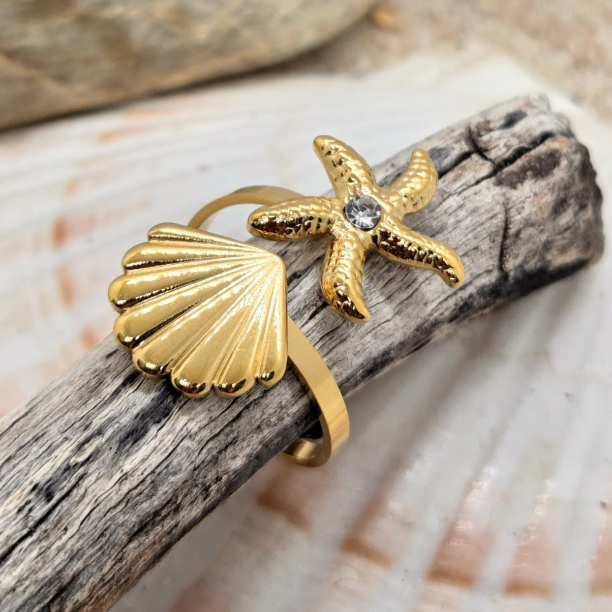 Gold bracelet with shell and starfish design on a wooden surface