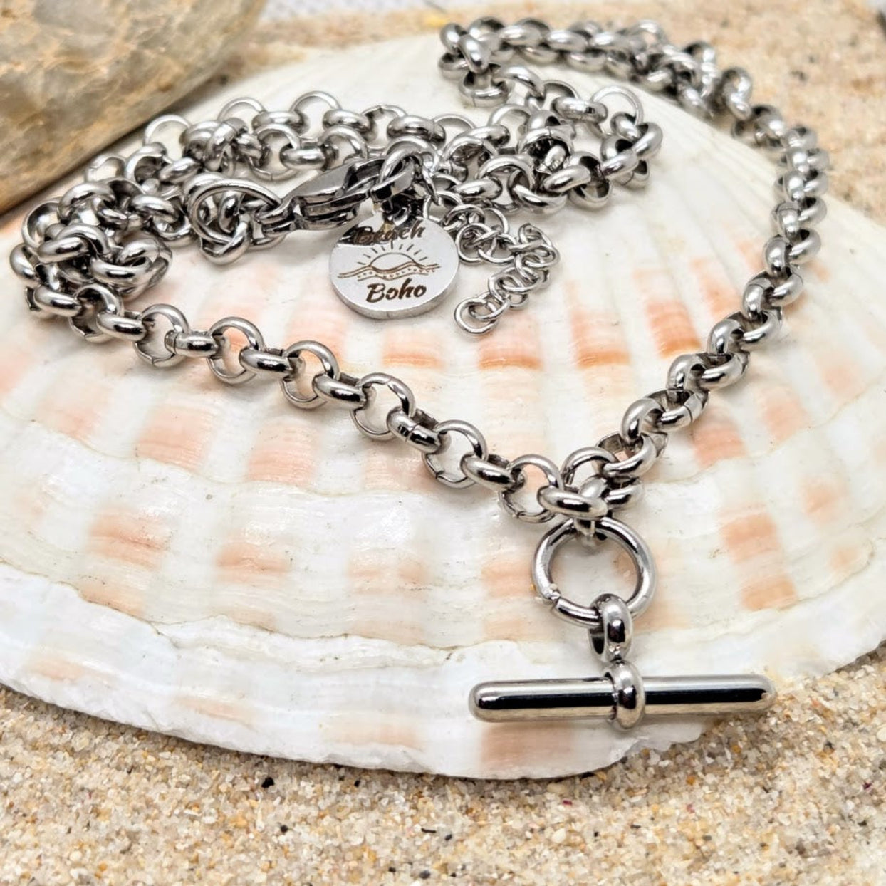 Silver chain bracelet with a toggle clasp on a seashell