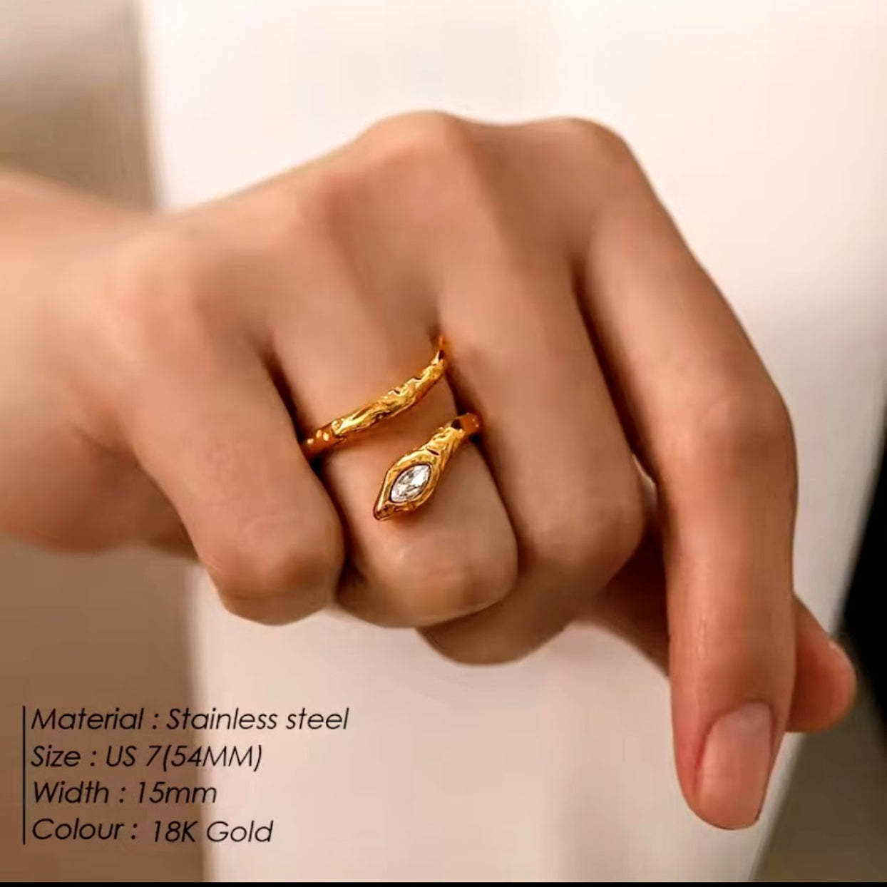 Gold ring on a finger with product details text overlay