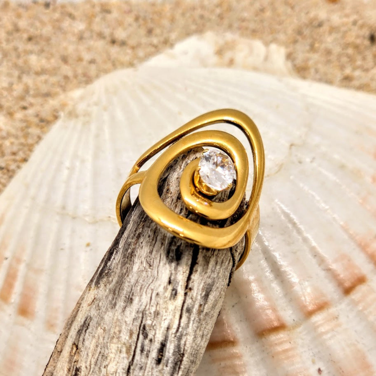 Gold ring with a diamond on a shell and wood background