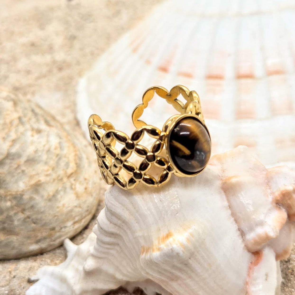 Gold ring with a black gemstone on a seashell