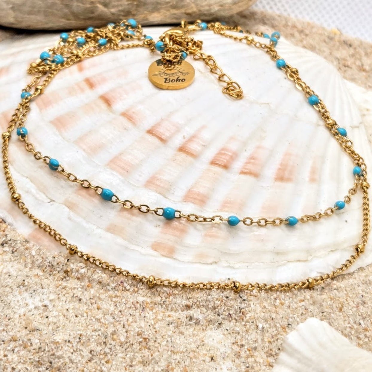 Gold necklace with blue beads on a seashell