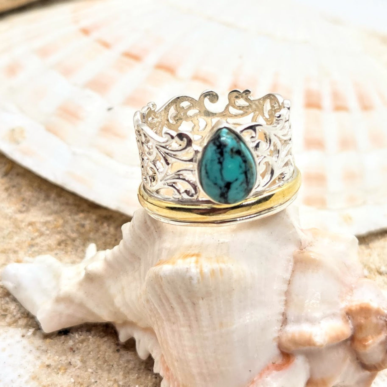 Silver ring with a turquoise stone on a seashell