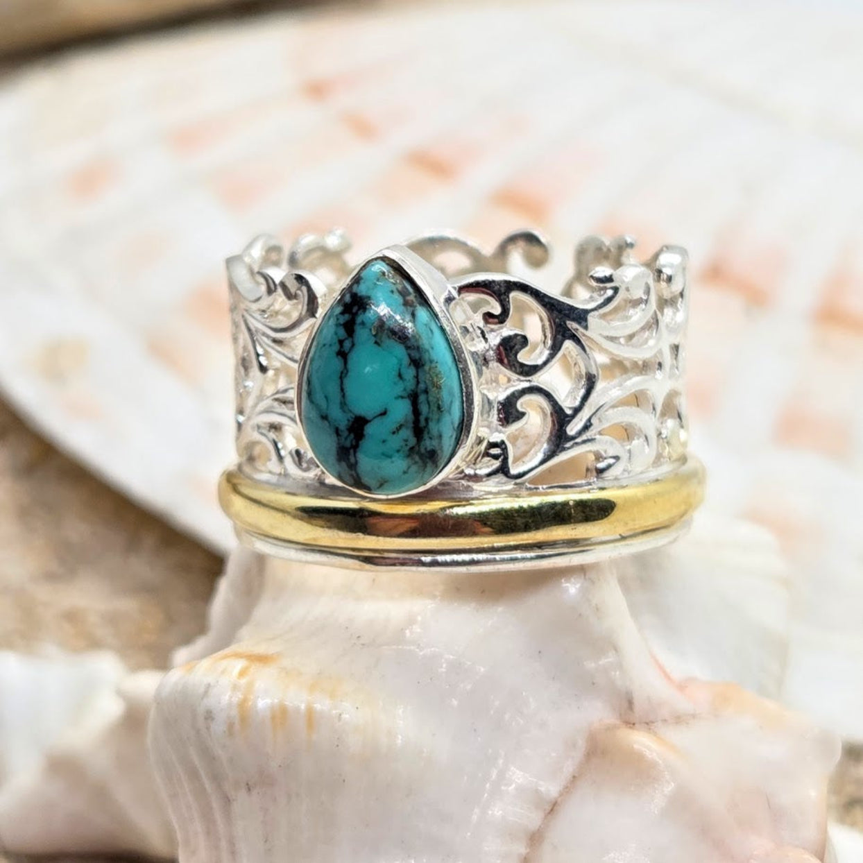 Silver ring with turquoise stone on a shell background