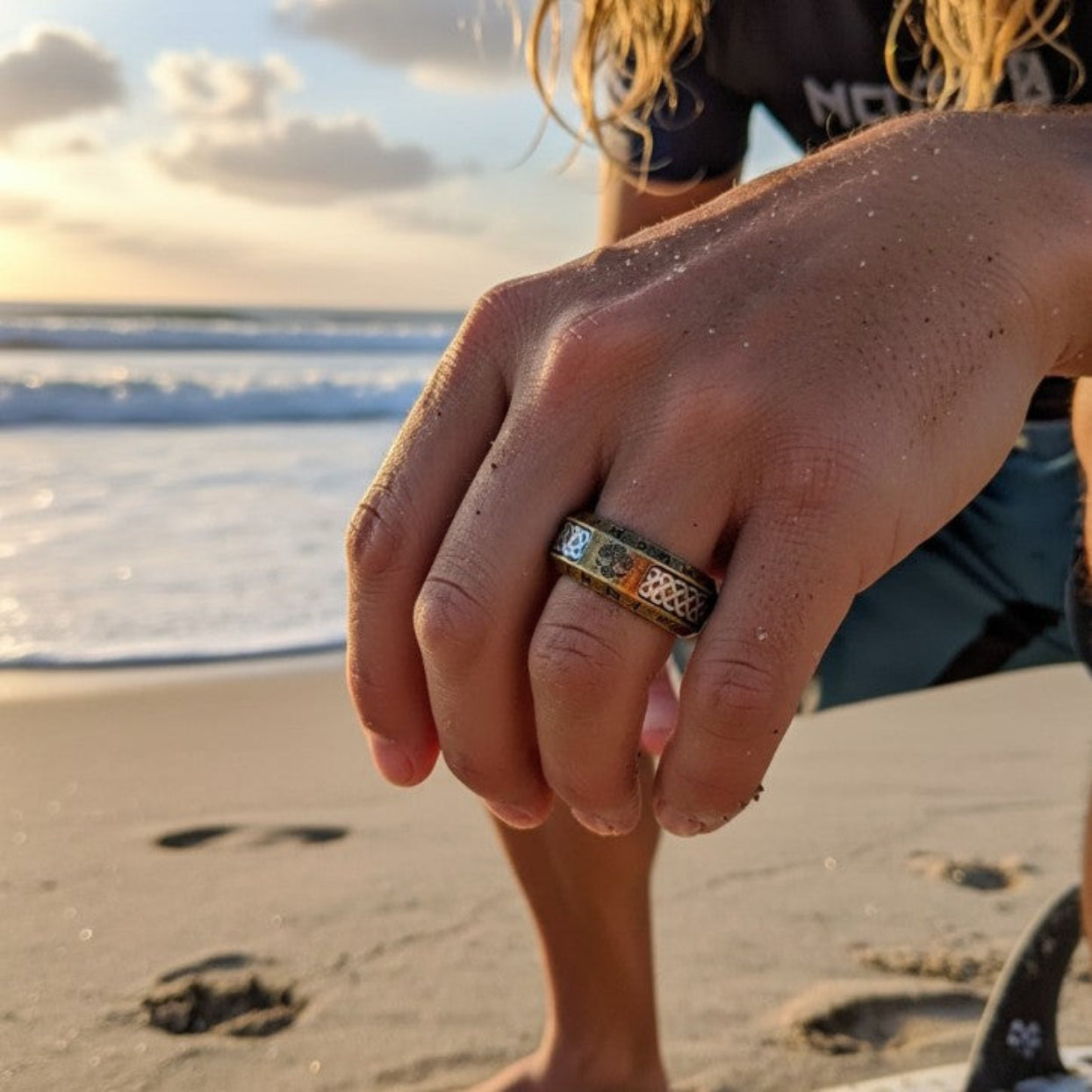 Hand with a ring on a beach