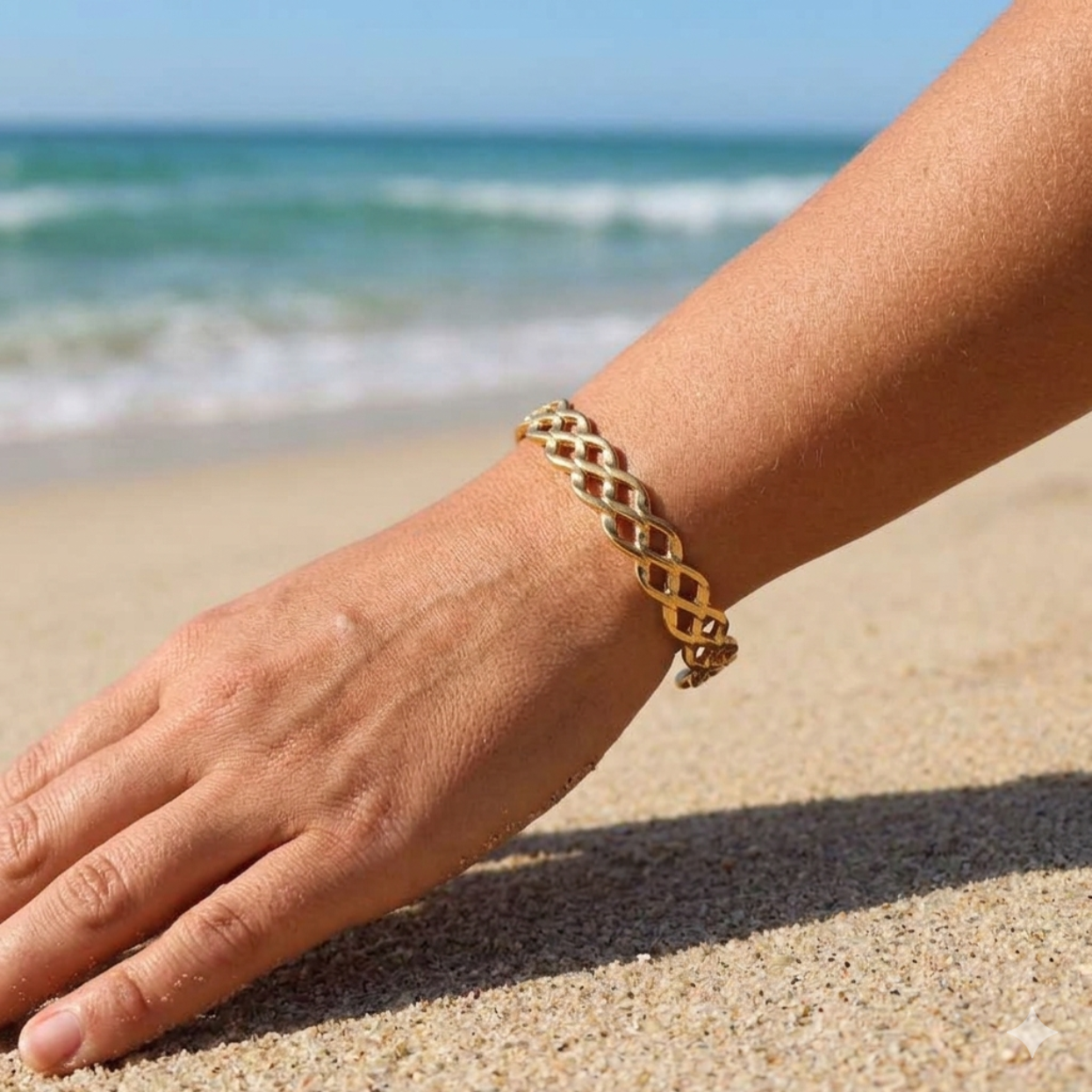 Gold bracelet on a wrist with a beach background